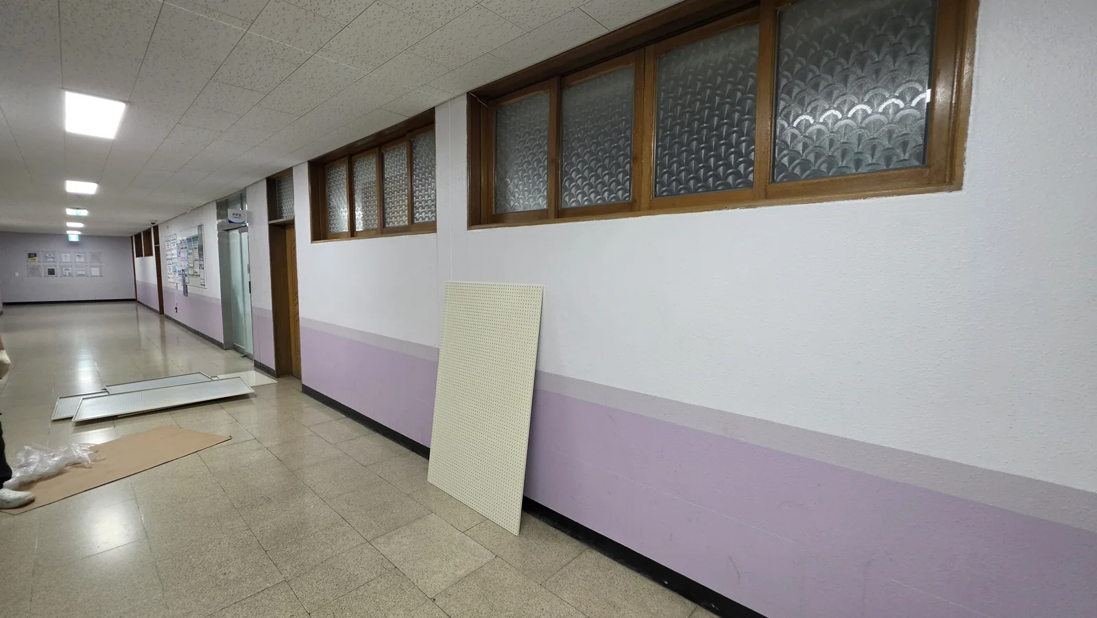 학교 복도 벽면과 설치 전 타공판 패널